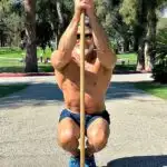 athlete increasing ankle mobility with pole stretch