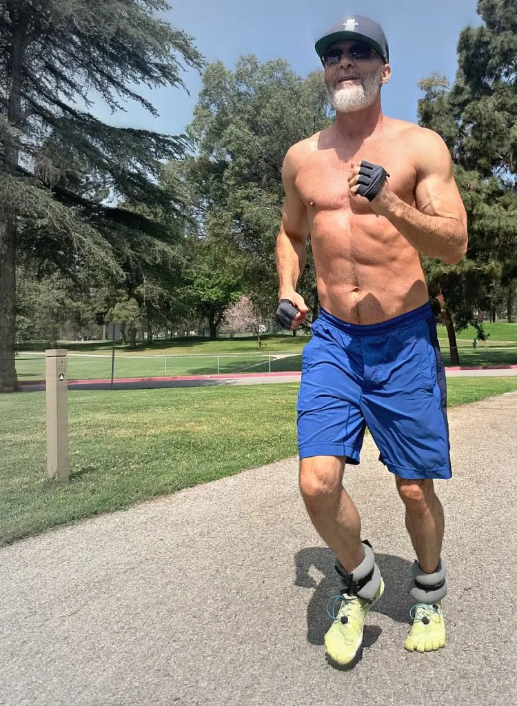 Dane Findley, age 53, does exercises with ankle weights outdoors.