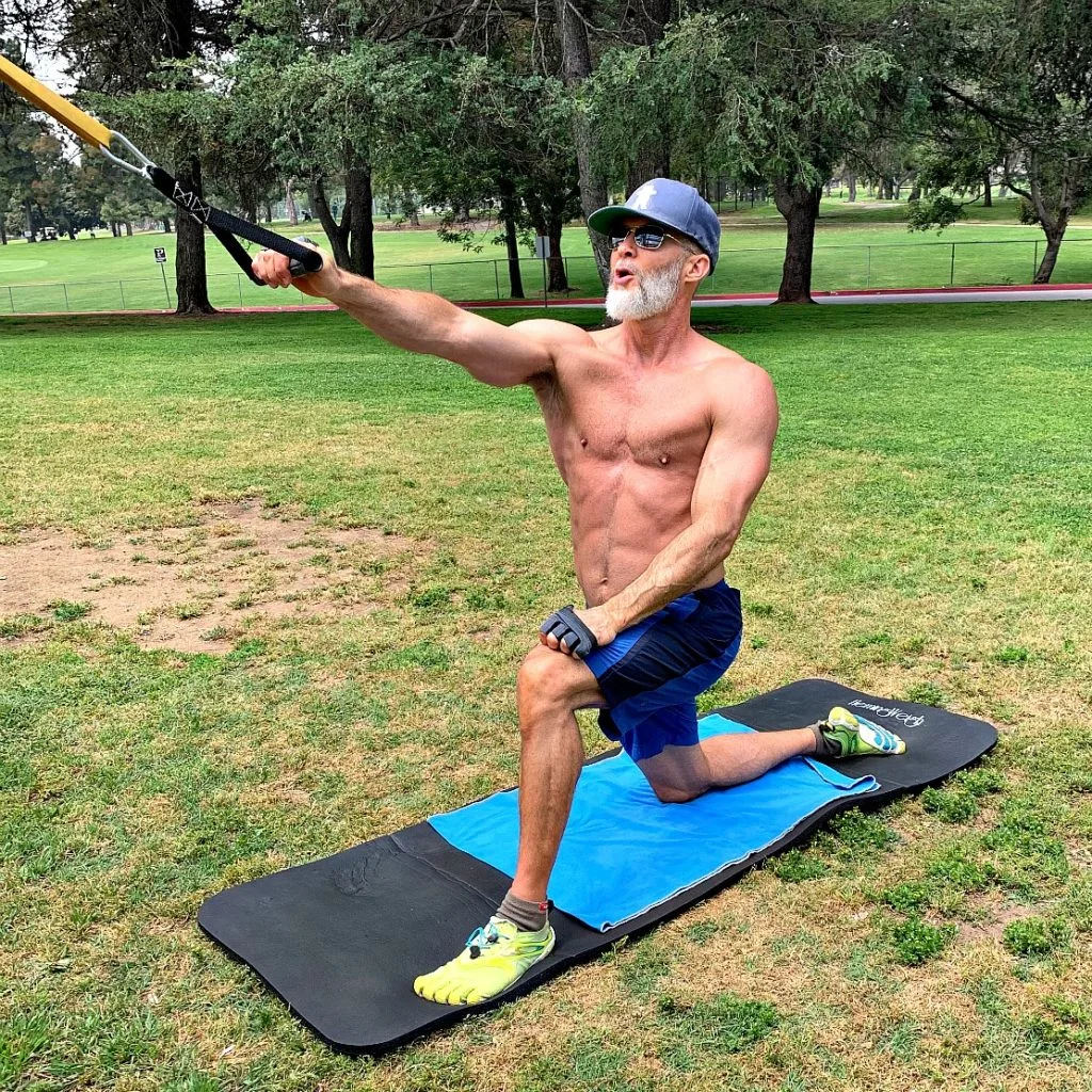 Older athlete using a resistance band to develop his back muscles.