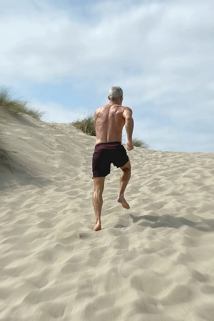 mature athlete running sprints at the beach to demonstrate health for men