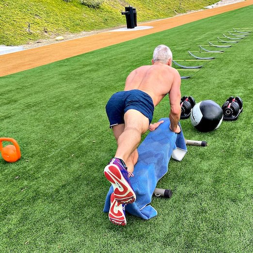 Male athlete does outdoor exercise to strengthen his glute muscles and legs.