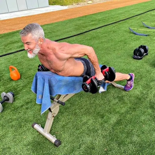 Older athlete improves posture by doing rear deltoid dumbbell fly exercise on back day.