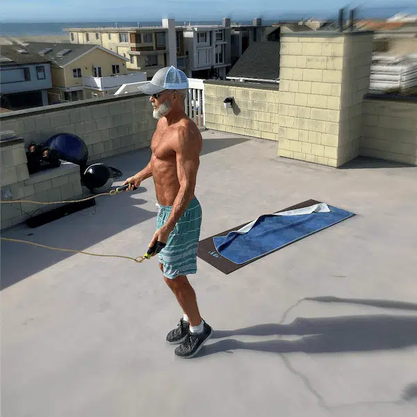 Mature athlete jumping rope during rooftop workout.
