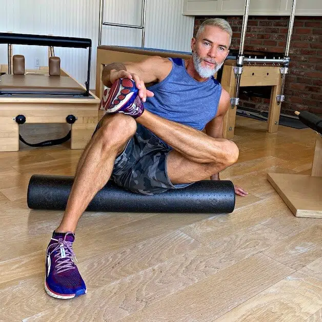mature man does cool-down on foam roller after workout.