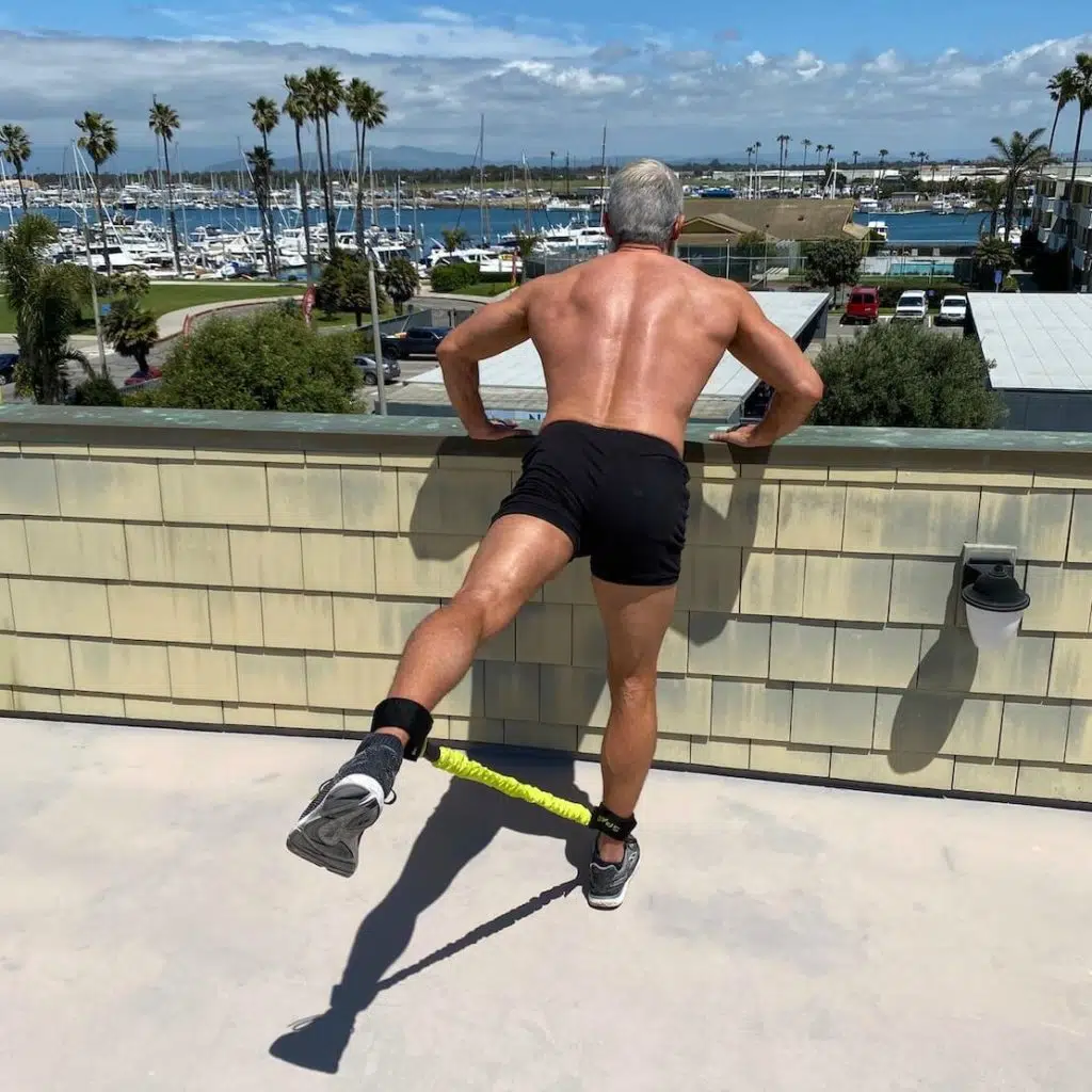Mature athlete trains his glutes using resistance bands.