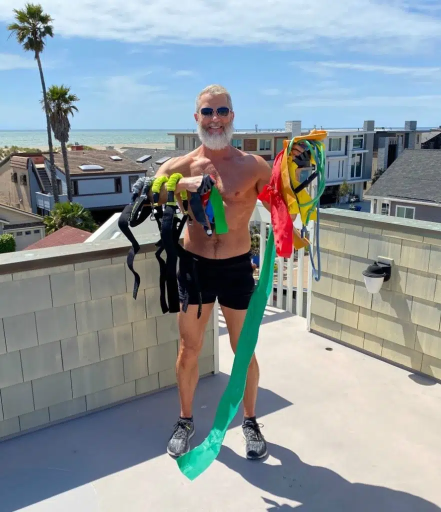 Mature athlete holding a variety of resistance bands in preparation for a leg workout.