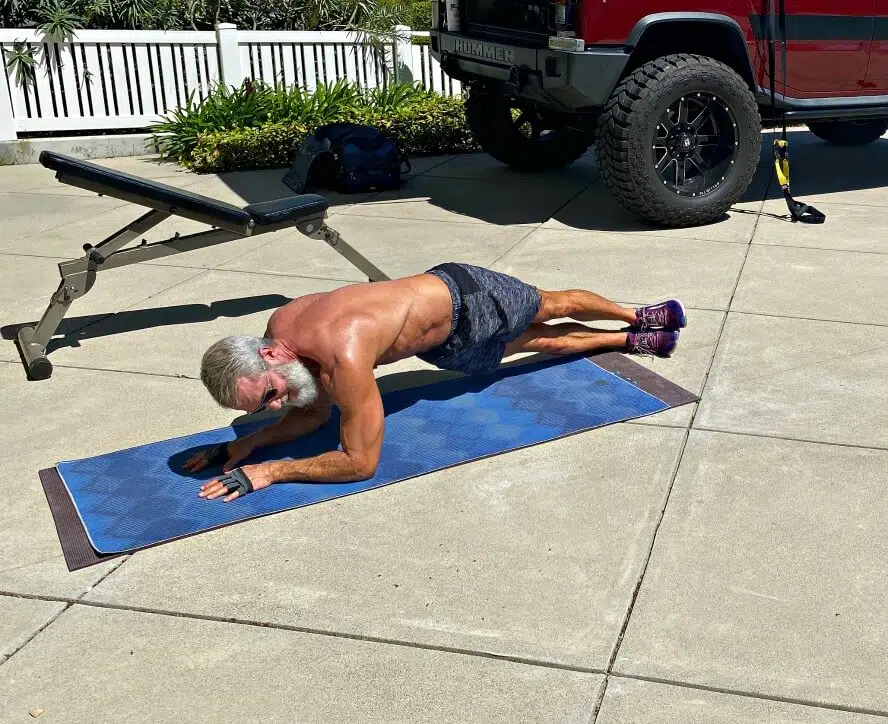 CrossFit for Over 50 – Man does abdominal training in the sun and fresh air of his driveway.