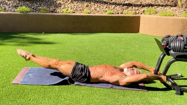 silver-haired man in his fifties does calisthenic abs workout