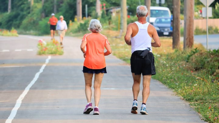 mature healthy couple controlling middle-age spread with outdoor exercise