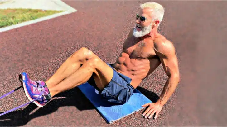 Older man getting stronger doing core exercises in the fresh air.